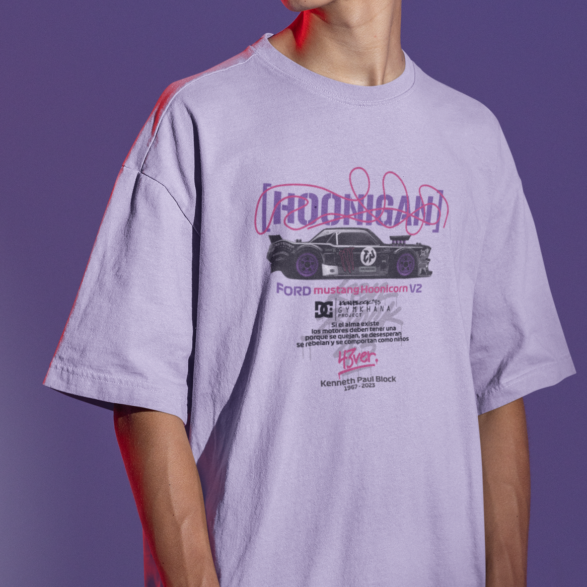Person wearing a light purple t-shirt with a graphic design on a purple background
