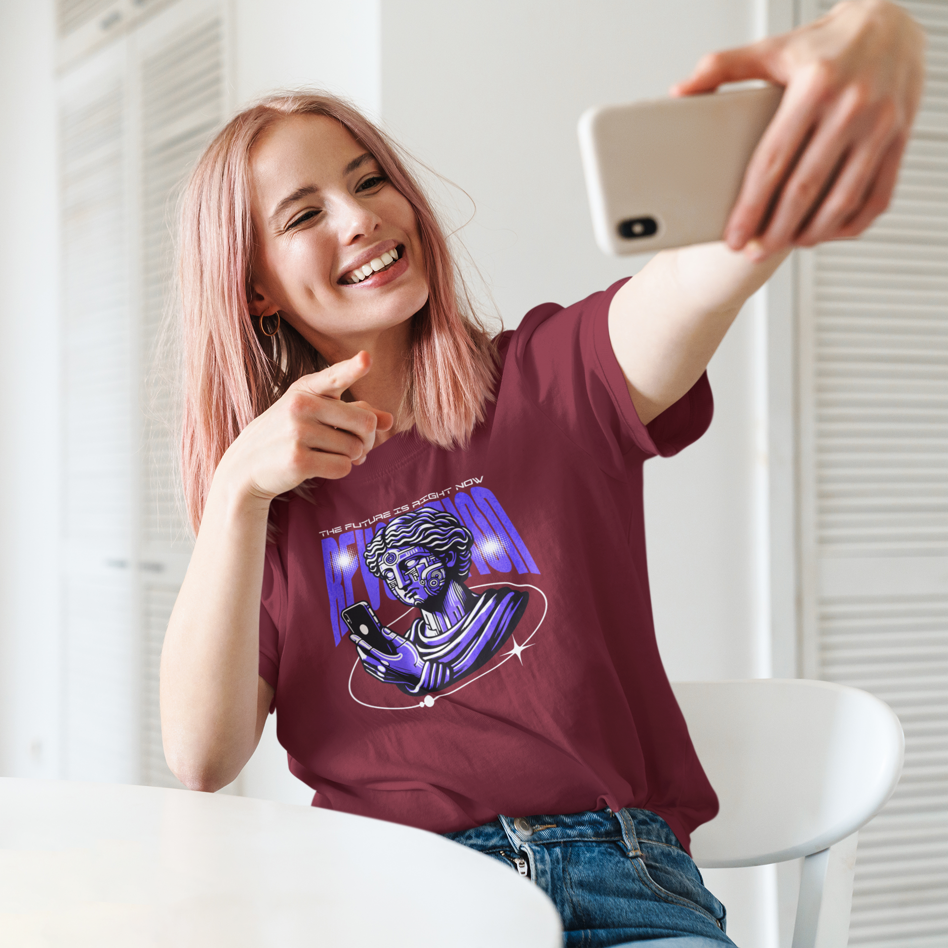 Person taking a selfie wearing a maroon t-shirt with a graphic design.